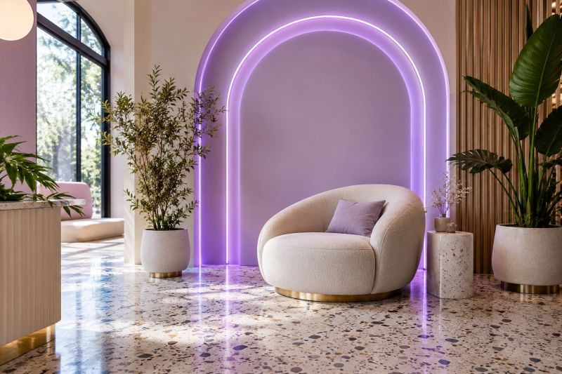 Kemerli lavanta duvarı mor LED neon çizgilerle çevrelenmiş, beyaz koltuklu ve terrazzo zeminli salon köşesi