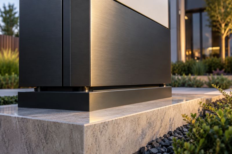 Taş kaide üzerindeki koyu metal totem gövdesinin panel birleşimi ve alt montaj detayı